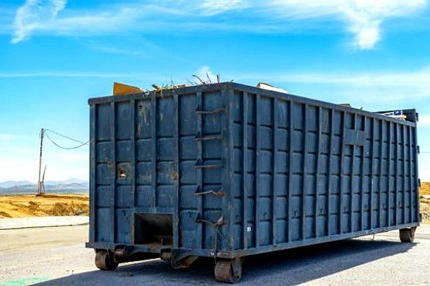 Iron Ridge Dumpster Works roll-off delivery truck and driver operating in Birmingham